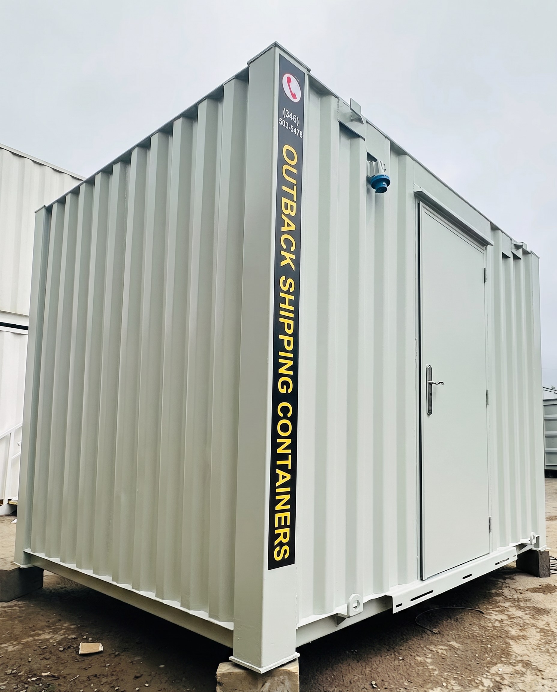 Light gray anti-vandal portable office cabin with a steel personnel door and corrugated metal exterior walls