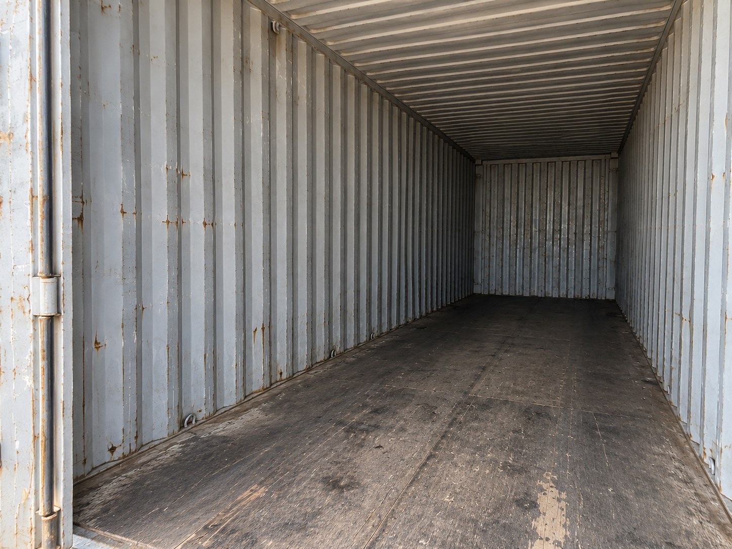 Used 40ft Cargo Container Double Doors — Angled interior view showing the floor, steel wall panels and roof with visible surface wear Used 40ft double-door cargo container — Angled interior view showing the floor, steel wall panels and roof with visible surface wear